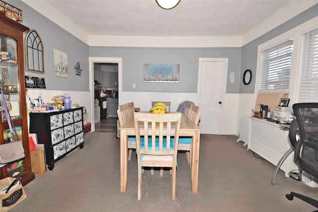 dining area featuring carpet and a wainscoted wall