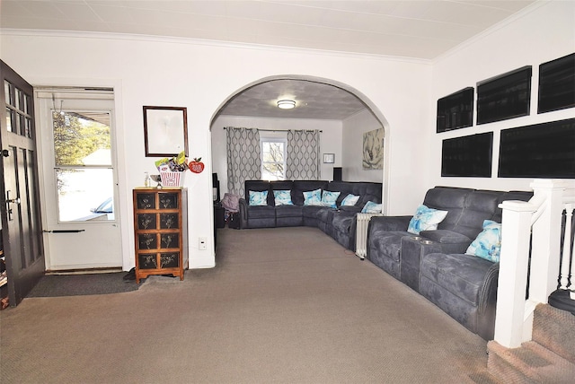 living area with arched walkways, ornamental molding, carpet flooring, and a wealth of natural light