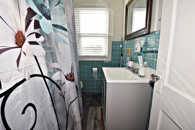 bathroom featuring a wainscoted wall, tile walls, and vanity