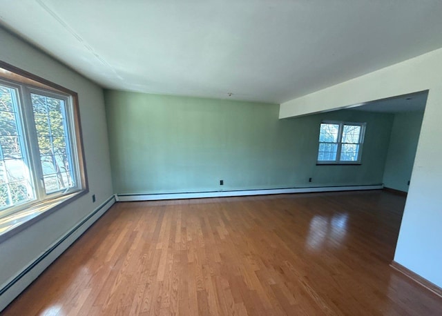 empty room with a baseboard heating unit, a baseboard radiator, and wood finished floors