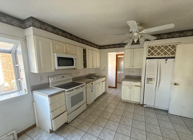 kitchen featuring a baseboard radiator, a ceiling fan, white cabinets, a sink, and white appliances