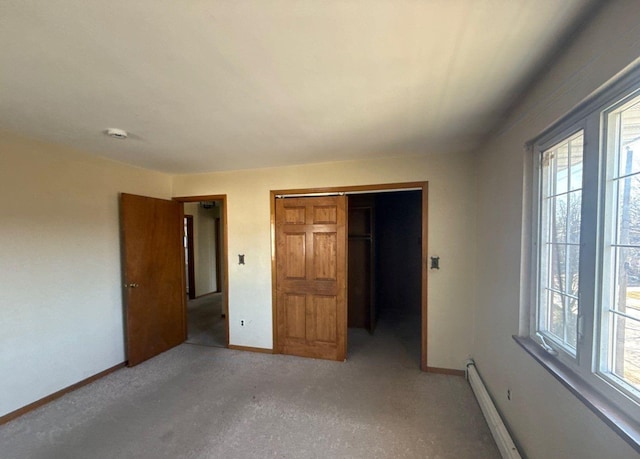 unfurnished bedroom featuring baseboards, baseboard heating, and a closet