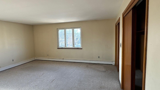 unfurnished bedroom featuring carpet floors and baseboard heating