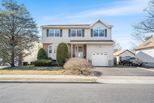 traditional home featuring brick siding, driveway, and an attached garage