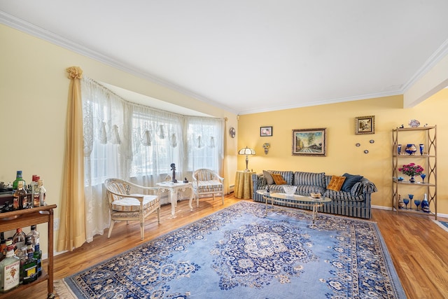 living area featuring crown molding, baseboards, and wood finished floors