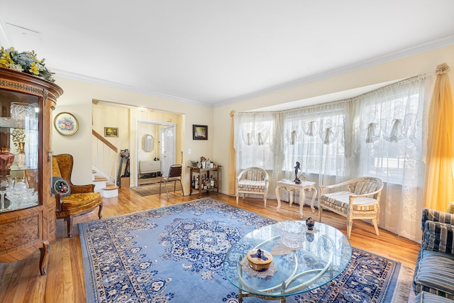 living area with light wood finished floors, stairs, and crown molding