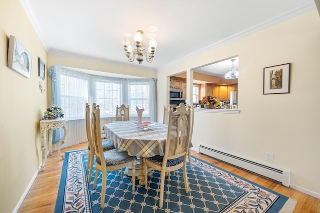 dining space with light wood-type flooring, baseboards, crown molding, and baseboard heating