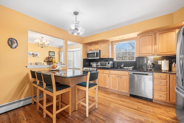 kitchen with appliances with stainless steel finishes, dark countertops, tasteful backsplash, and light brown cabinetry