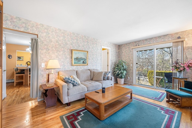 living room featuring baseboards, light wood finished floors, and wallpapered walls