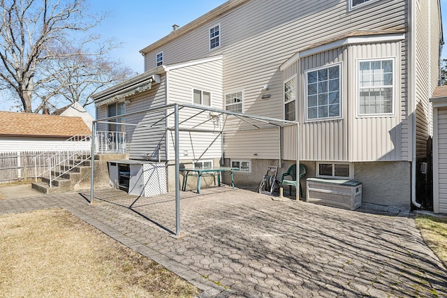 rear view of property featuring fence, board and batten siding, and a patio