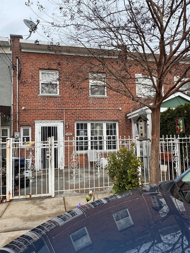 view of property with brick siding and a fenced front yard