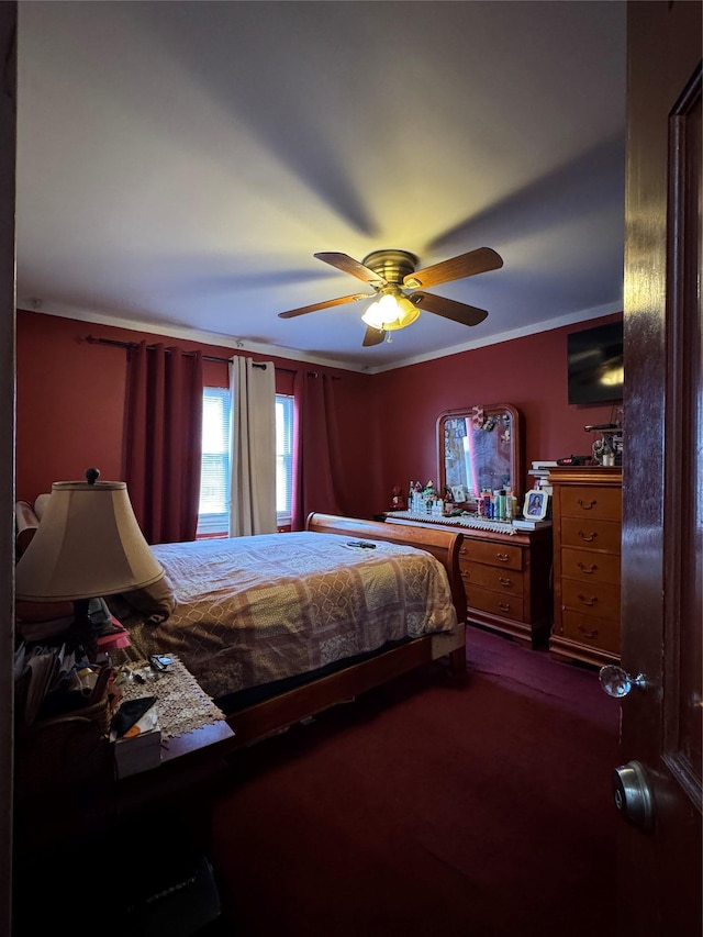 bedroom with crown molding, a ceiling fan, and dark colored carpet