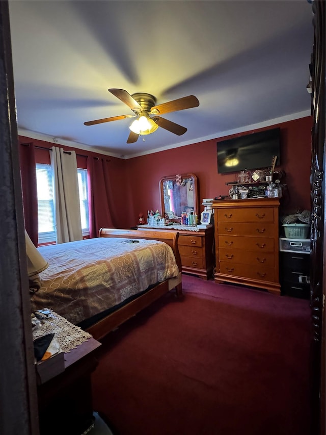 bedroom featuring dark colored carpet, a ceiling fan, and crown molding