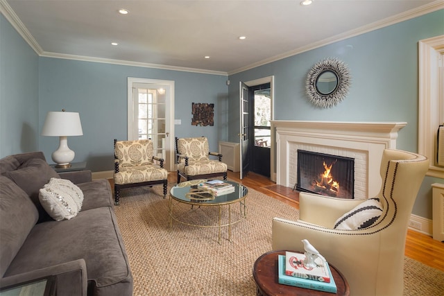 living room with recessed lighting, a fireplace, crown molding, and wood finished floors