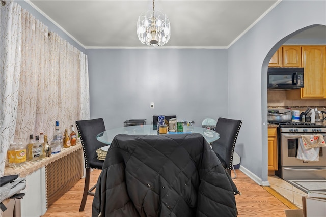 dining area featuring arched walkways, a notable chandelier, crown molding, and light wood finished floors