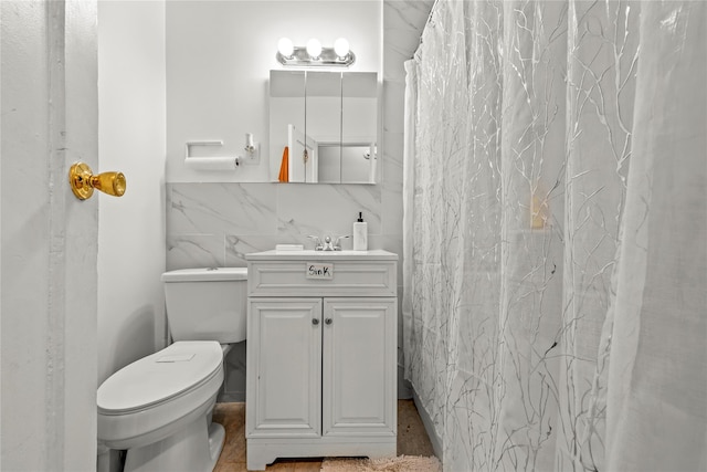 full bathroom with tile walls, vanity, and toilet