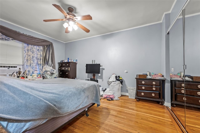 bedroom with light wood-style floors, cooling unit, a closet, and ornamental molding