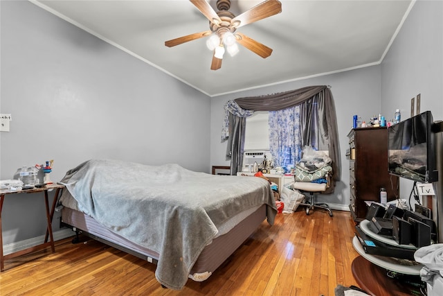 bedroom featuring light wood-style flooring, ornamental molding, and baseboards