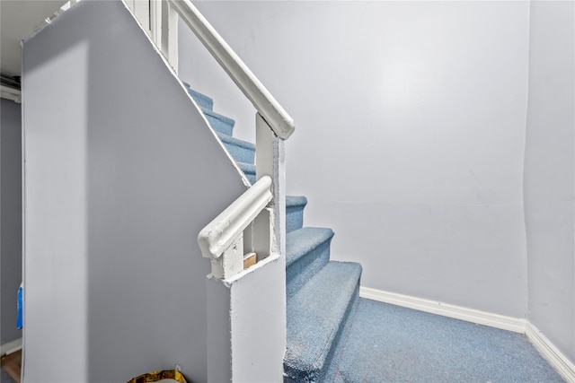 stairway featuring carpet and baseboards