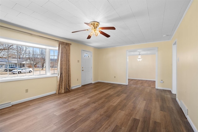 spare room with a ceiling fan, wood finished floors, visible vents, and baseboards