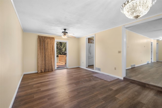 empty room featuring visible vents, baseboards, wood finished floors, and ceiling fan with notable chandelier