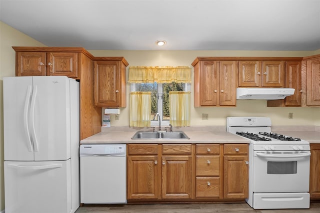 kitchen featuring under cabinet range hood, white appliances, light countertops, and a sink