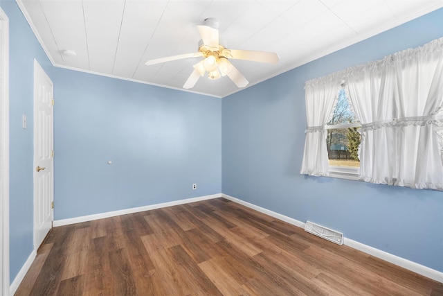 unfurnished room featuring visible vents, crown molding, baseboards, and wood finished floors