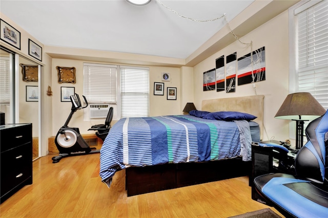 bedroom with cooling unit and wood finished floors