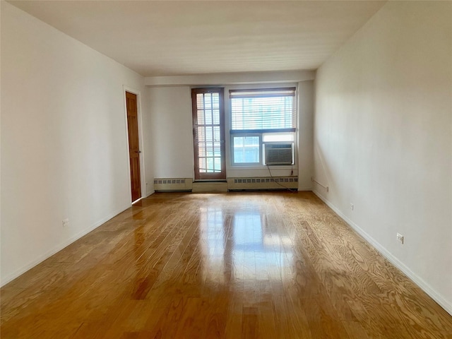 97-37 63rd Rd Unit 9H, Rego Park, NY 11374 - unfurnished room featuring a baseboard heating unit, wood finished floors, and cooling unit