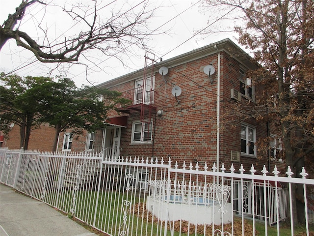 view of front of home with a fenced front yard and brick siding