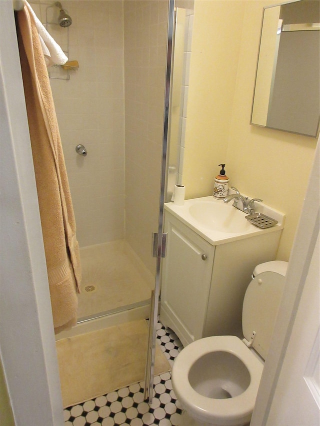 bathroom with toilet, a stall shower, tile patterned floors, and vanity