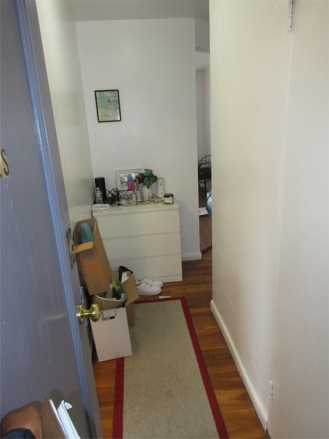 hallway with baseboards and wood finished floors