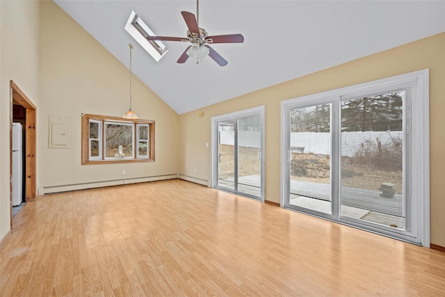 unfurnished living room featuring a baseboard heating unit, a skylight, light wood-type flooring, and ceiling fan