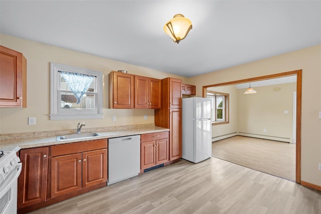 kitchen featuring white appliances, brown cabinetry, baseboard heating, light countertops, and a sink