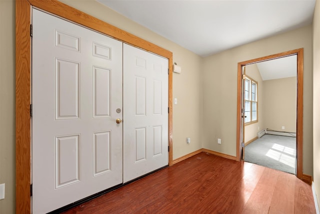 entryway with baseboards, a baseboard heating unit, and wood finished floors