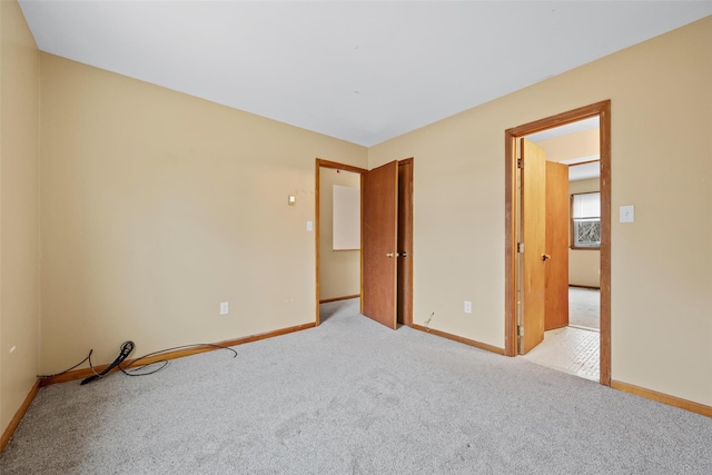 carpeted empty room with baseboards