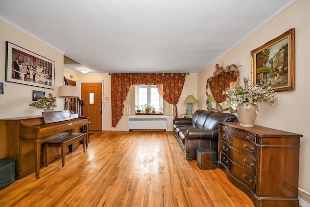 sitting room featuring ornamental molding and light wood-style floors