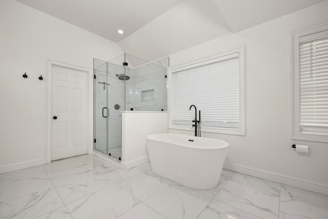 bathroom featuring lofted ceiling, marble finish floor, a shower stall, baseboards, and a freestanding bath