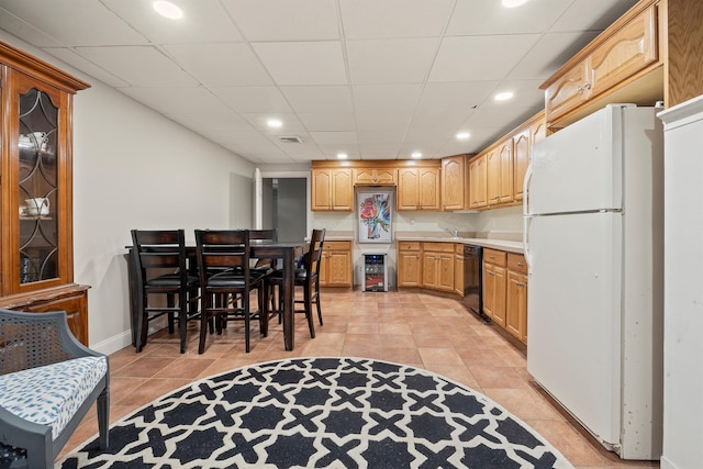 kitchen featuring light countertops, light tile patterned floors, black dishwasher, and freestanding refrigerator