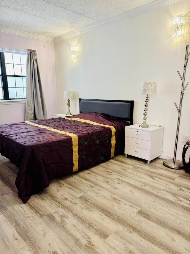 bedroom with crown molding and wood finished floors