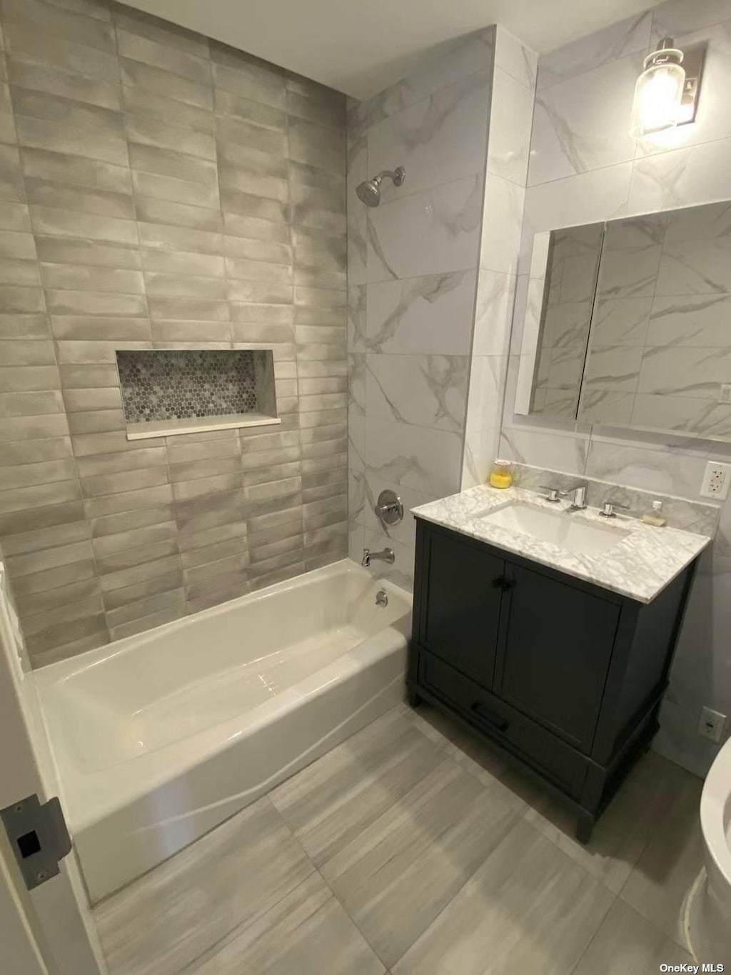 bathroom featuring bathing tub / shower combination, vanity, and tile walls