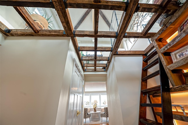 stairs featuring beamed ceiling and a towering ceiling