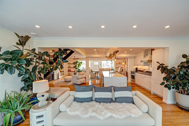 living room with crown molding, light wood-style flooring, and recessed lighting