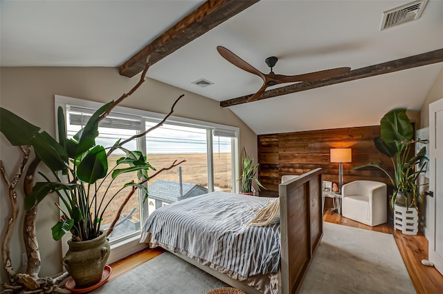 bedroom with vaulted ceiling with beams, wood finished floors, and visible vents