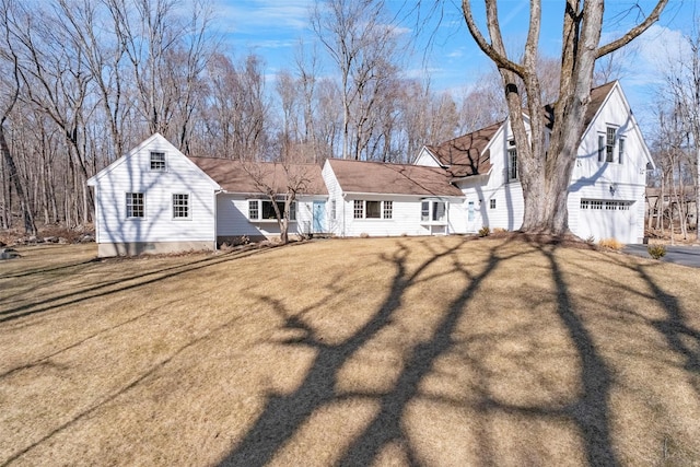 view of front of property featuring a garage, driveway, and a front lawn