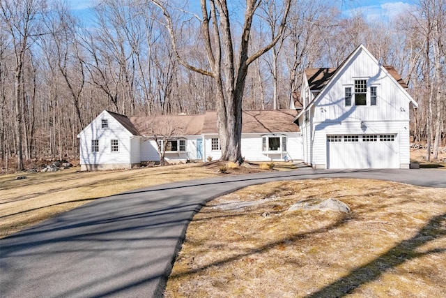 modern farmhouse style home with a garage, aphalt driveway, and board and batten siding