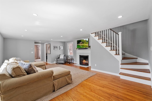 living area featuring light wood-style floors, recessed lighting, baseboards, and stairs