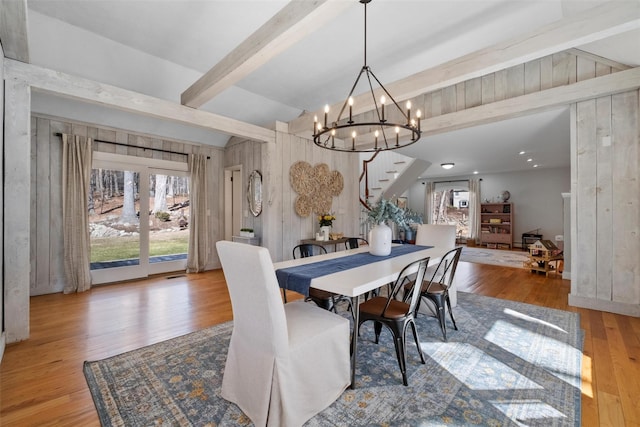 dining space featuring beam ceiling, wood-type flooring, visible vents, stairway, and a chandelier