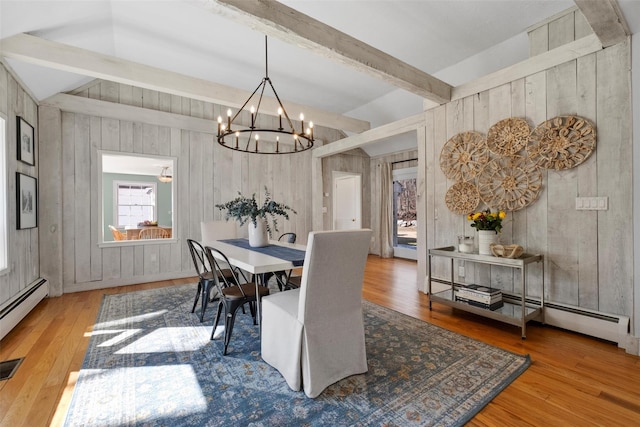 dining space with vaulted ceiling with beams, a baseboard radiator, a chandelier, and wood finished floors