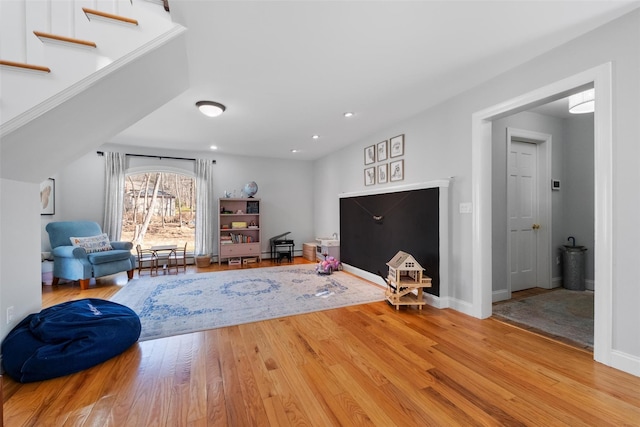 living room with recessed lighting, wood-type flooring, and baseboards